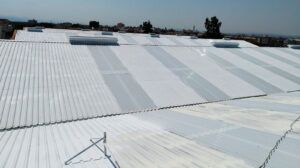 Cubierta industrial renovada con chapa metálica blanca y lucernarios por OBRASOC impermeabilización en Murcia