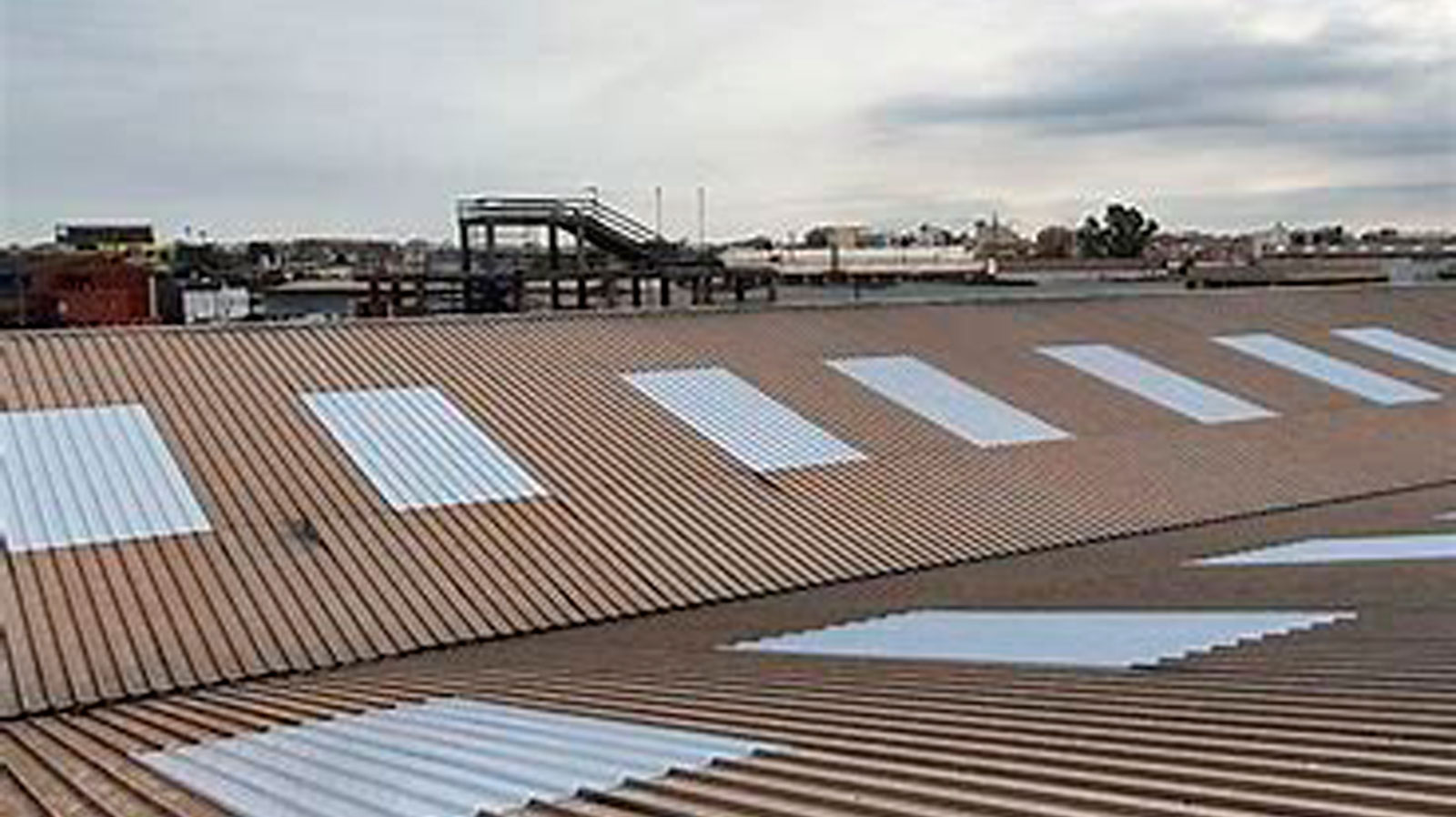 Cubierta industrial de fibrocemento con lucernarios traslúcidos renovados por OBRASOC en nave industrial